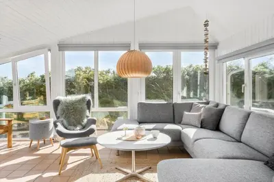 a living room with a couch and a table and chairs at BL123-Blokhus-Nonnestien-8 in Blokhus