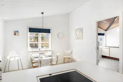 a white living room with a table and chairs at BL1284-Blokhus-Tyttebaervej-4 in Blokhus