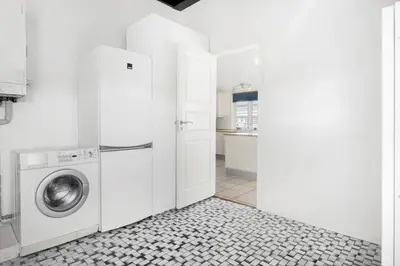 a white laundry room with a washer and dryer at BL1284-Blokhus-Tyttebaervej-4 in Blokhus