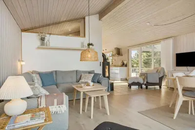 a living room with a blue couch and a table at BL1458-Blokhus-Lyngmarken-6 in Blokhus