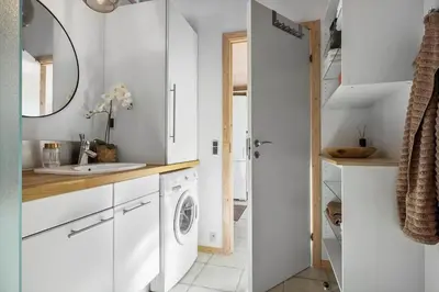 a white kitchen with a sink and a washing machine at BL1458-Blokhus-Lyngmarken-6 in Blokhus