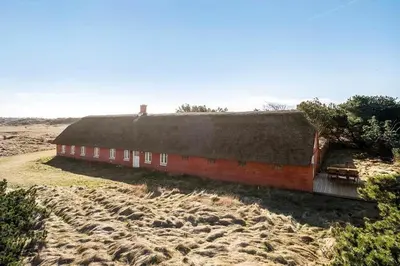 a red building with a thatched roof in a field at BL1249-Pandrup-Rodhus-Klitvej-80 in Pandrup