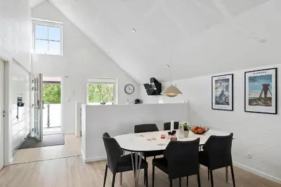a white dining room with a table and chairs at BL1287-Blokhus-Klitgaardsvej-3-A-1-2 in Blokhus