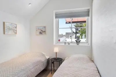 a bedroom with two beds and a window at BL1287-Blokhus-Klitgaardsvej-3-A-1-2 in Blokhus