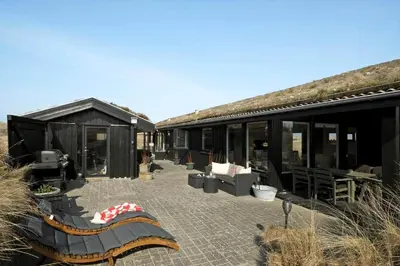 a building with a patio with chairs and tables at BL1173-20-Pandrup-Hunetorp-Klitvej-119 in Pandrup