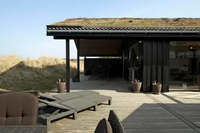 a patio with chairs and a building with a roof at BL1173-20-Pandrup-Hunetorp-Klitvej-119 in Pandrup