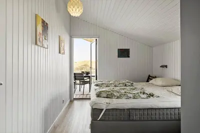 a bedroom with a bed and a balcony at BL1173-20-Pandrup-Hunetorp-Klitvej-119 in Pandrup