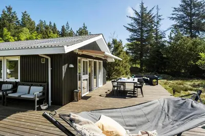 a wooden deck with a table and chairs on it at BL1101-Pandrup-Rodhusparken-56 in Pandrup