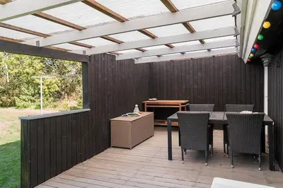 a patio with a table and chairs and a white pergola at BL1293-Saltum-Havmandens-Vej-24 in Saltum