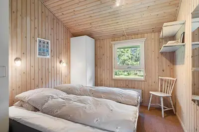 a bedroom with a couch in a room with wooden walls at BL1293-Saltum-Havmandens-Vej-24 in Saltum