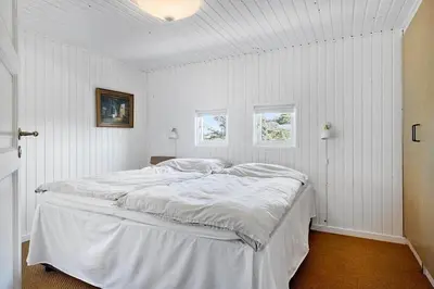 a white bedroom with a large bed in it at BL1100-Blokhus-Klitvejen-44 in Blokhus