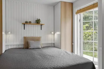 a bedroom with a bed and a window at BL1109-Blokhus-Bag-Hojen-78 in Blokhus