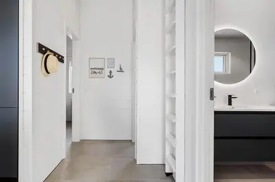 a white bathroom with a sink and a mirror at BL1295-Saltum-Vesterhavs-Sletten-39 in Saltum