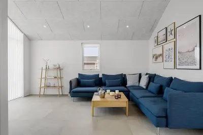 a living room with a blue couch and a table at BL1295-Saltum-Vesterhavs-Sletten-39 in Saltum