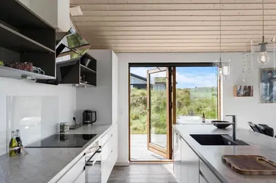 a kitchen with white counters and a large sliding glass door at BL1104-Saltum-Borgvej-45 in Saltum