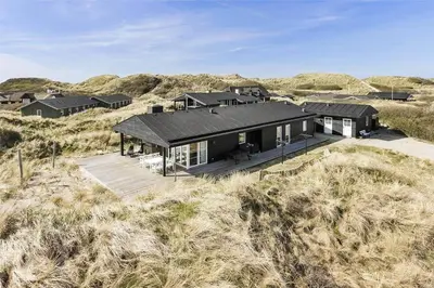 a black house in the middle of a field at BL1310-Blokhus-Moreavej-33-A in Blokhus