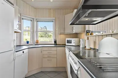 a kitchen with a sink and a stove top oven at BL271-Blokhus-Taarnfalkevej-15 in Blokhus