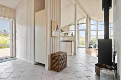 a large room with a kitchen with white tile floors at BL271-Blokhus-Taarnfalkevej-15 in Blokhus