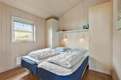 a large bed in a room with a window at BL271-Blokhus-Taarnfalkevej-15 in Blokhus