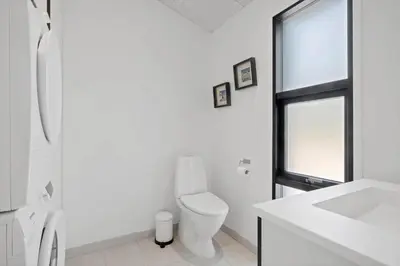 a white bathroom with a toilet and a window at BL1765-Blokhus-Plantagevej-2B in Blokhus