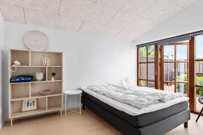 a bedroom with a large bed and a large window at BL1117-Blokhus-Peter-Andersensvej-10 in Blokhus