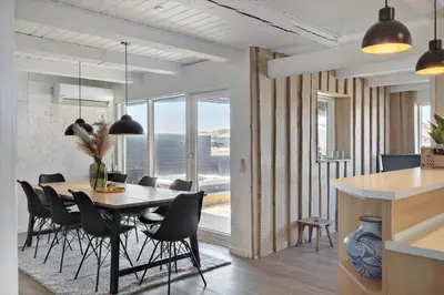 a kitchen and dining room with a table and chairs at 258-Harboore-Merchantvej-5 in Harboør