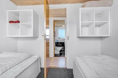 a bedroom with two beds and a bathroom with a toilet at G430-Lemvig-Myntevej-30 in Lemvig
