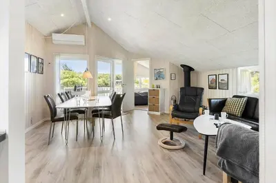 a dining room and living room with a table and chairs at 168-Harboore-Emblavej-1 in Harboør