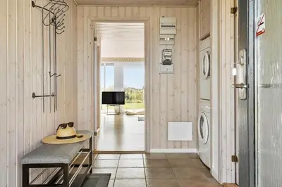 a hallway with a table and a washing machine at 115-Harboore-Strandvejen-164 in Harboør