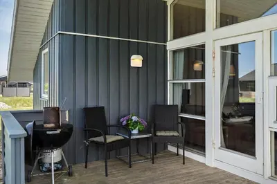 a screened in porch with chairs and a table at 286-Harboore-Neerlandiavej-198 in Harboør
