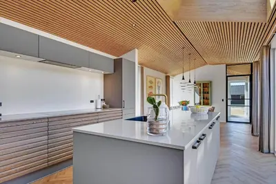 a kitchen with a white counter top and wooden ceilings at 265-Harboore-Lucievej-6-b in Harboør