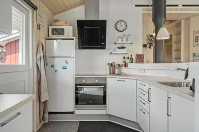 a kitchen with white cabinets and a refrigerator at 600-Lemvig-Porsevej-115 in Lemvig