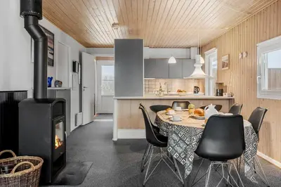 a kitchen and dining room with a table and a stove at 123-Harboore-Vejlby-Klit-83 in Harboør