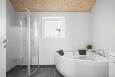 a white bathroom with a tub and a window at G245-Lemvig-Porsevej-45 in Lemvig