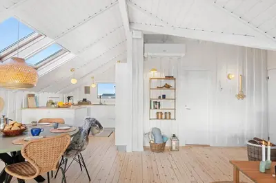 a room with a table and chairs and a kitchen at 254-Harboore-Vejlby-Klit-251 in Harboør