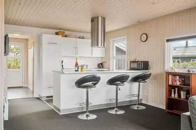 a kitchen with two bar stools and a counter at 153-Harboore-Vejlby-Klit-77 in Harboør