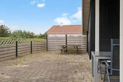 a bench sitting on a patio next to a fence at 153-Harboore-Vejlby-Klit-77 in Harboør