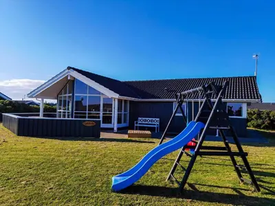 a playground with a slide in front of a house at 234-Harboore-Neerlandiavej-21 in Harboør