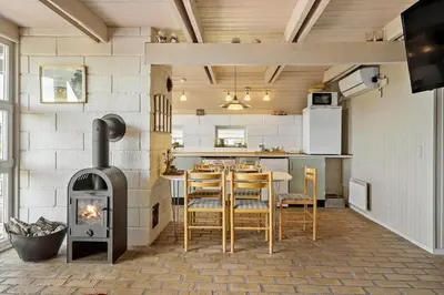 a kitchen with a stove and a table with chairs at 300-Harboore-Fourmivej-29 in Harboør