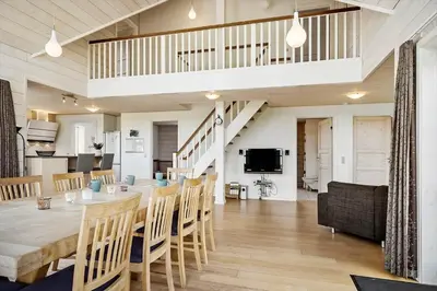a dining room and living room with a table and chairs at 289-Harboore-Strandvejen-179 in Harboør