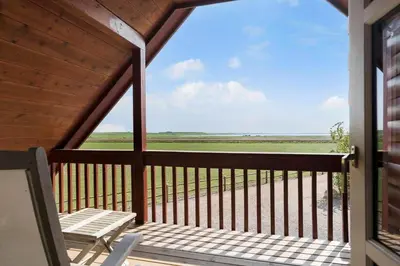 a porch with a bench and a view of a field at 289-Harboore-Strandvejen-179 in Harboør