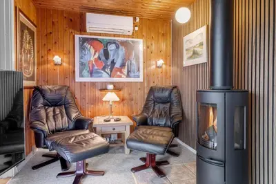 a living room with two chairs and a fireplace at 111-Harboore-Vejlby-Klit-125 in Harboør