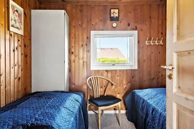 a bedroom with a bed and a chair and a window at 111-Harboore-Vejlby-Klit-125 in Harboør