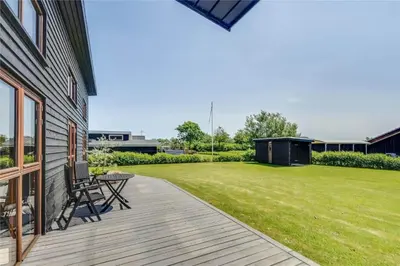 a deck with a table and chairs and a yard at G161-Lemvig-Porsevej-61 in Lemvig