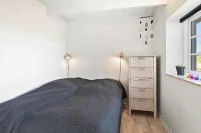 a bedroom with a bed and a dresser and a window at 180-Harboore-Doblervej-89 in Harboør