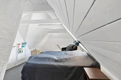 a room with a bed in a white attic at 180-Harboore-Doblervej-89 in Harboør