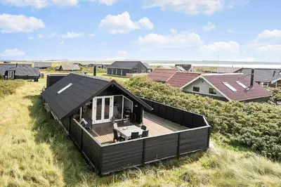 a house on the beach with a deck at 225-Harboore-Neerlandiavej-268 in Harboør