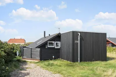 a black clad house on a gravel road at 225-Harboore-Neerlandiavej-268 in Harboør