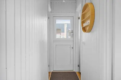 a hallway with a white door and a window at 225-Harboore-Neerlandiavej-268 in Harboør