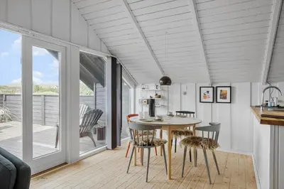 a kitchen with a table and chairs in a room at 225-Harboore-Neerlandiavej-268 in Harboør